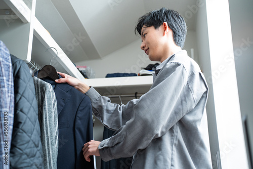 クローゼットで服を選ぶ日本人男性