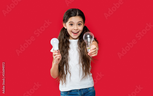 photo of amazed teen girl has solution with bulb. teen girl has solution isolated on red.