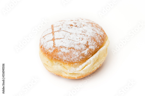 Single isolated Krapfen or Berliner doughnut dusted with icing sugar, traditional German fried Brioche dough pastry filled with vanilla custard for New Year's or carnival party on white background
