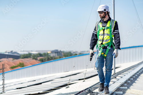 Male engineer installing or checking the working condition of solar panels on the roof or at the height of the factory for saving electricity was broken to use renewable energy from the sun