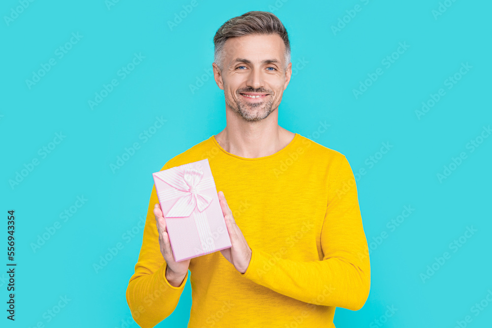 positive man shopper with present isolated on blue. man shopper with present in studio. positive man shopper with present isolated on blue. man shopper with present in studio.