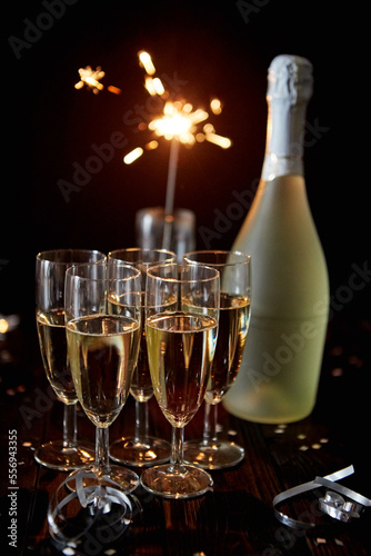 Party composition image. Glasses filled with champagne placed on black table