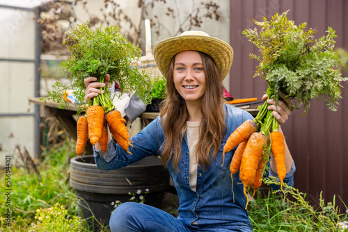 Fotografie Happy farm worker showing off the harvested vegetables