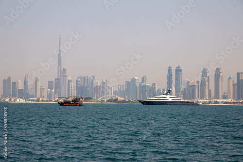 Panorama of famous Dubai with ship against skyscrapers in UAE