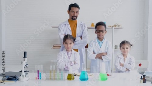 4K, School Girls Boys Girls in the school science classroom when the experiment is successful them and the science teacher Standing cross-legged in front of a table where test tubes are placed. photo