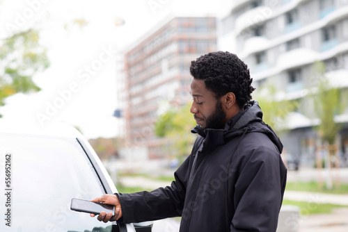 Man using mobile app for renting car photo