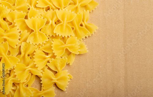 Raw Farfalle Pasta Texture Background, Yellow Dry Butterfly Noodles Pattern, Wheat Bow Macaroni on Craft Paper