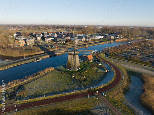Strijkmolen E, Ouddorp, Alkmaar, North Holland,The Netherlands. Oak octagonal polder mill from 1630. Ironing mills do not drain polders, grind the water from one reservoir to the other. Winter aerial. photo