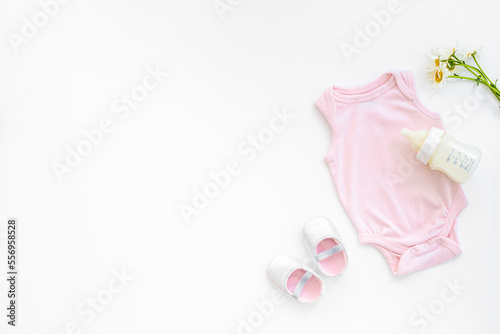 Baby girl bodysuit with toys and accessories, flat lay