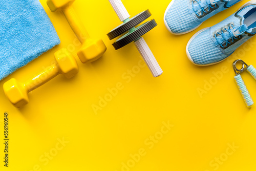 Sport fitness background with sneakers and dumbbells, top view