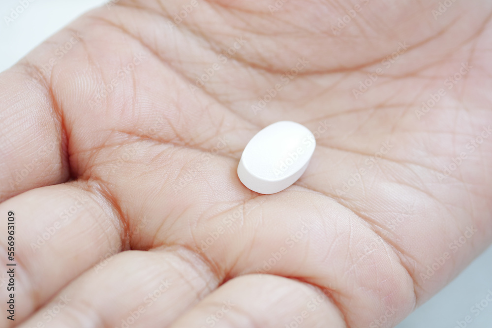 Close up of man hand holding pills with copy space Close up of man hand holding pills with copy space
