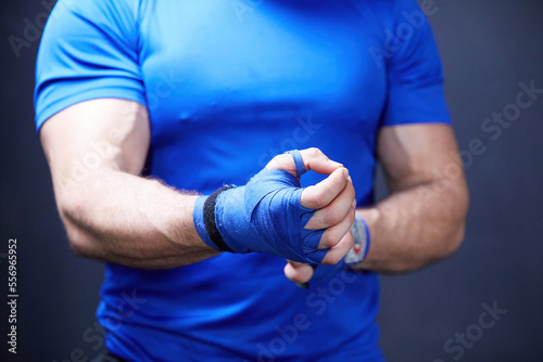 close up boxer wrapping hand with blue bandage and prepare to fight
