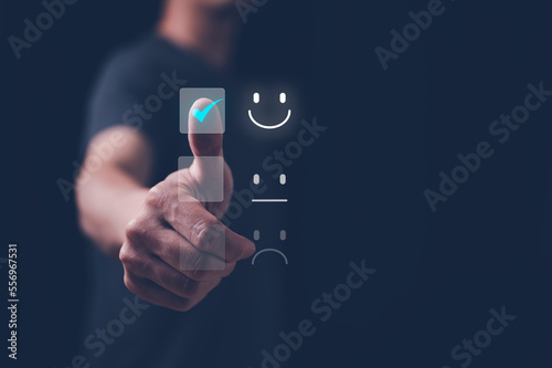 Customer service satisfaction survey concept.Business people or customers show satisfaction by pressing face emoticon smile in satisfaction on virtual touch screen.
