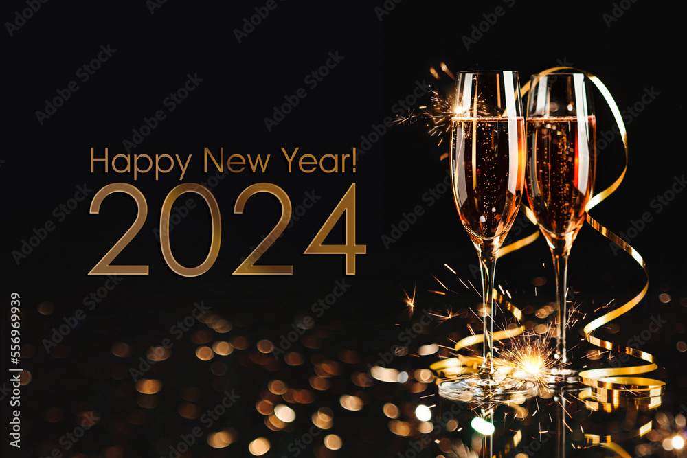 Happy New Year 2024! Two glasses with champagne, ash and serpentine bokeh on a dark background