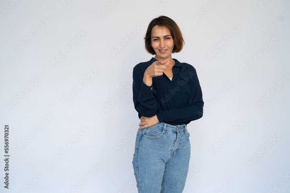Confident woman pointing at camera. Female model in dark blue shirt recruiting employees. Portrait, studio shot, employment concept Confident woman pointing at camera. Female model in dark blue shirt recruiting employees. Portrait, studio shot, employment concept