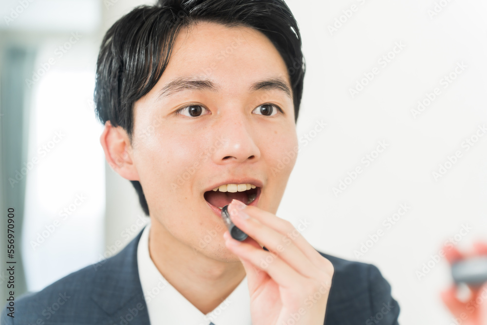 リップを塗る若い日本人男性