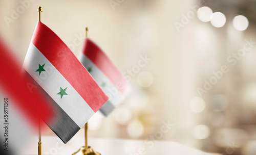 Small flags of the Syria on an abstract blurry background