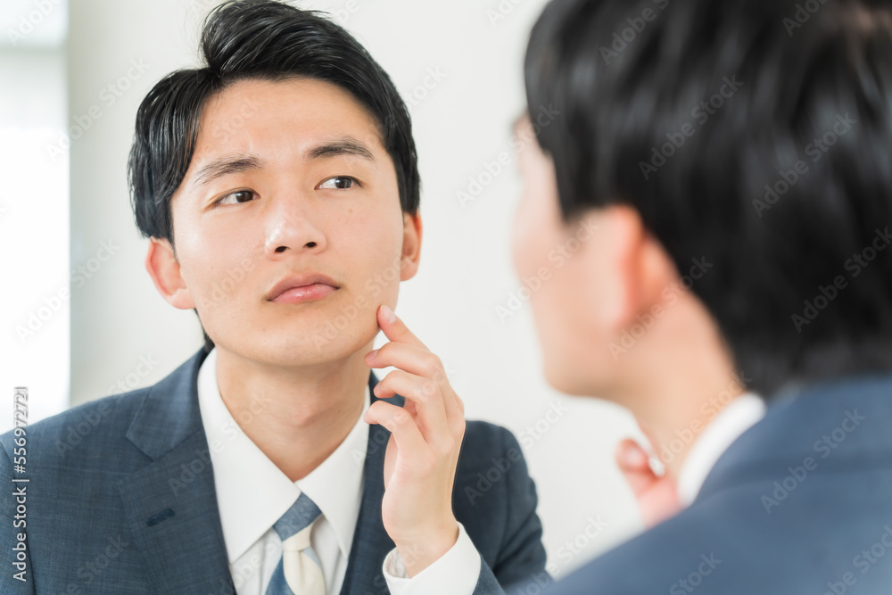 肌をチェックする若い日本人男性 肌をチェックする若い日本人男性