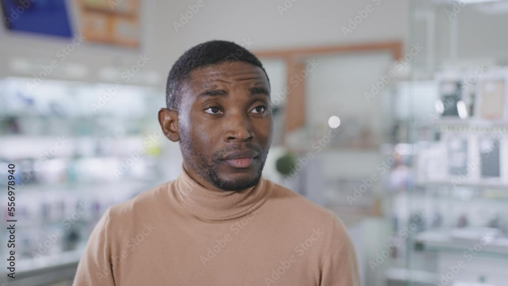 African man in an electronics and gadgets store. The seller-consultant tells the buyer about goods and services.