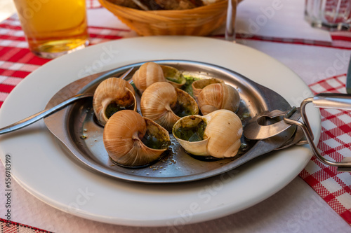 Starter dish in traditional restaurants on Burgundy, snails cooked with butter, garlic and herbs