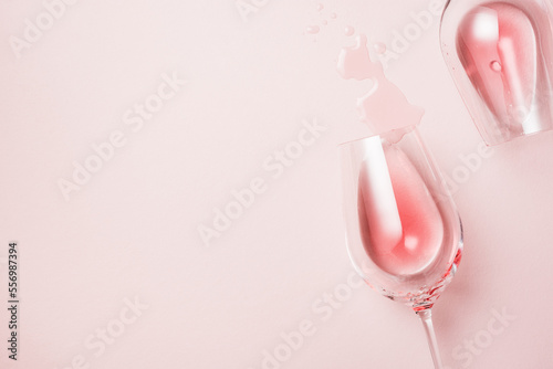 Two glasses of rose wine on a pink surface.