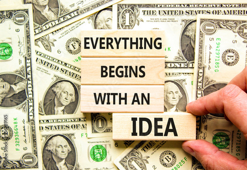 Everything begins with an idea symbol. Concept word Everything begins with an idea on wooden blocks. Beautiful background from dollar bills. Business everything begins with an idea concept. Copy space