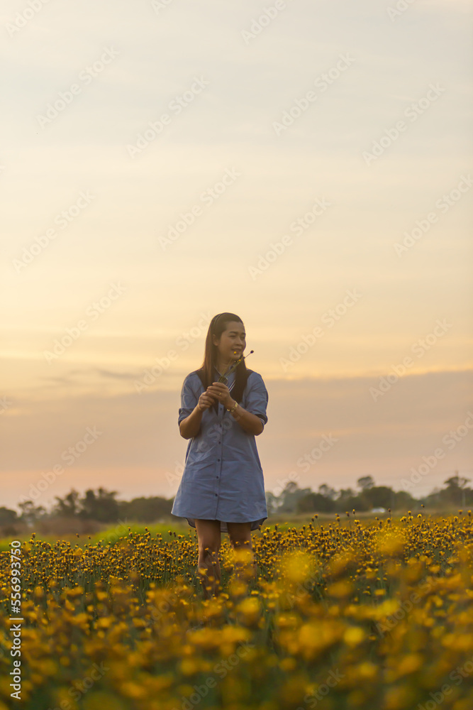 Fototapeta premium A beautiful girl is enjoying on the flower garden.The relaxation of the girl after hard work. , natural tourism.