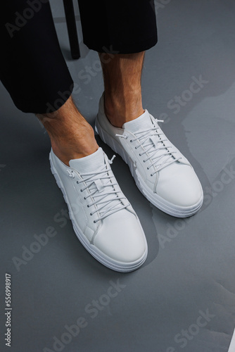 Modern men's shoes. Male legs in black pants and white casual sneakers. Men's fashionable shoes © Дмитрий Ткачук