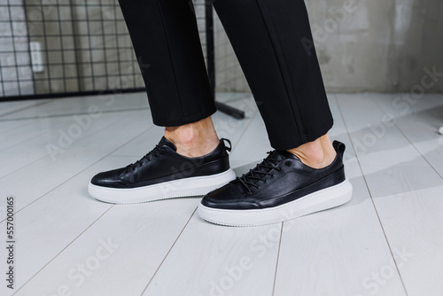 Wallpaper Mural Modern men's shoes. Male legs in black pants and black casual sneakers. Men's fashionable shoes Torontodigital.ca