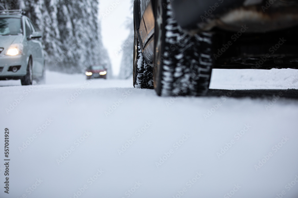 Car on a snowy winter road amid forests - using its four wheel drive capacities to get through the snow Car on a snowy winter road amid forests - using its four wheel drive capacities to get through the snow