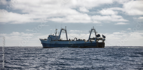 Large fishing trawler conducts industrial fishing in the open ocean.
