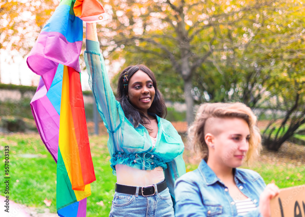 African girl holding the flag of the lgbt community in her hands while protesting for her rights. African girl holding the flag of the lgbt community in her hands while protesting for her rights.