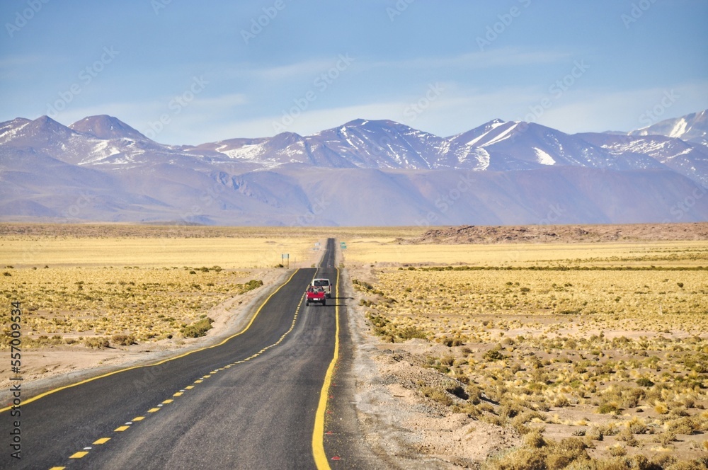 Long, endless, straight road in the Atacama desert, Chile. Two cars