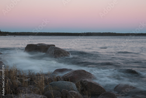 pink sunset on the stone shore and the raging sea