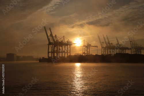 Dramatischer Sonnenaufgang über den Hamburger Hafen mit Nebel und Wolken im Winter 