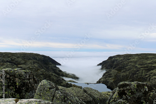 View from the top of the mountain of the Serra da Estrela natural park in Portugal. Cloudy and foggy day. Small water dam in the middle of the mountains.