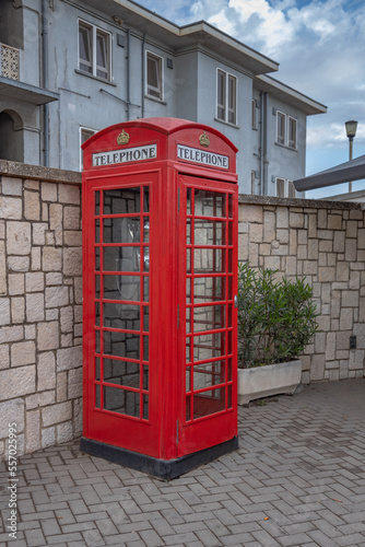 Gibraltar cityscape. Close up of empty typical English red telephone box close to Gibraltar Passport Control Station. UK 