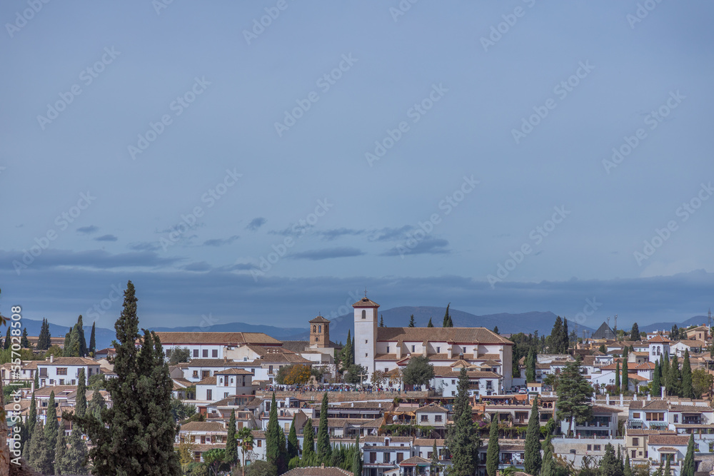 Amazing panorama of Granada city and Alhambra's Alcazaba fortress. Scenic view from Generalife gardens on a sunny day with blue sky above. Granada, Andalusia, Spain.                                   