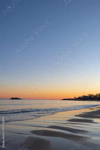 Crescent Moon During Sunset At The Sand Beach In Massachusetts, USA. Shades OF Orange Color At The Horizon. 