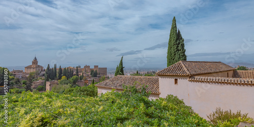 Amazing panorama of Granada city and Alhambra's Alcazaba fortress. Scenic view from Generalife gardens on a sunny day with blue sky above. Granada, Andalusia, Spain.                                   