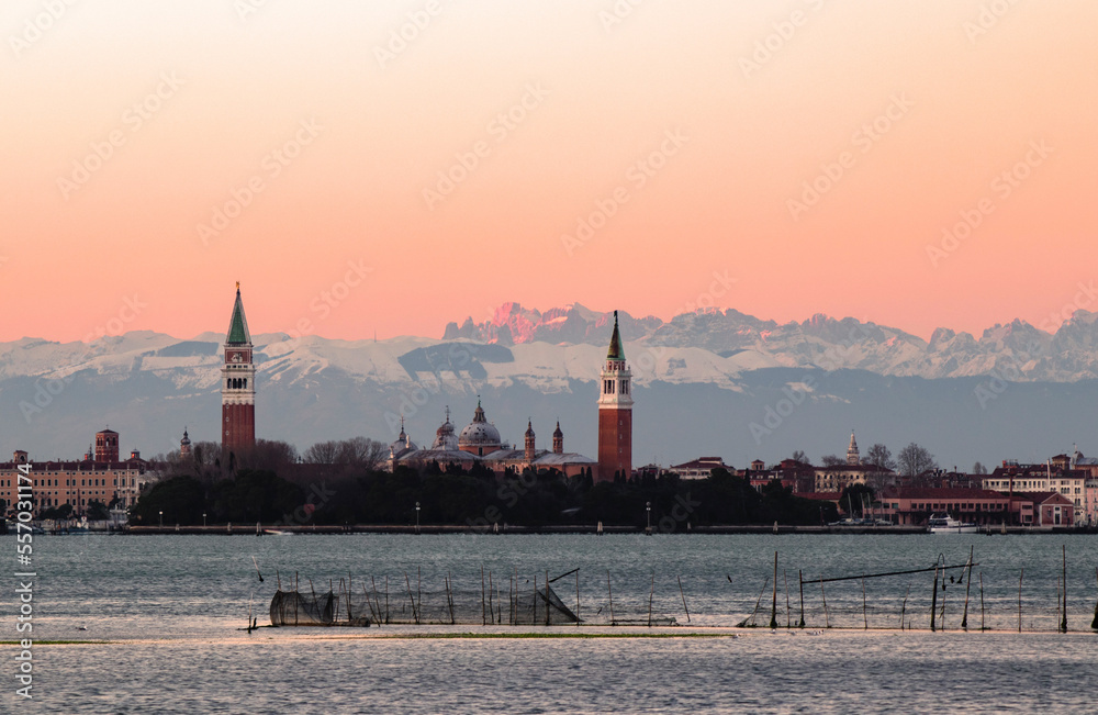 view of venice at sunset from the lagoon to the dolomite mountains