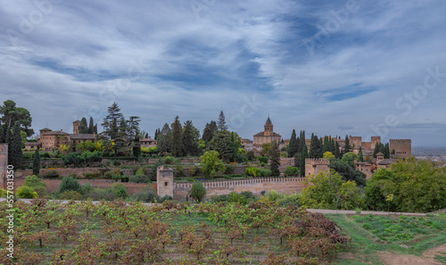 Amazing panorama of Granada city and Alhambra's Alcazaba fortress. Scenic view from Generalife gardens on a sunny day with blue sky above. Granada, Andalusia, Spain.                                   
