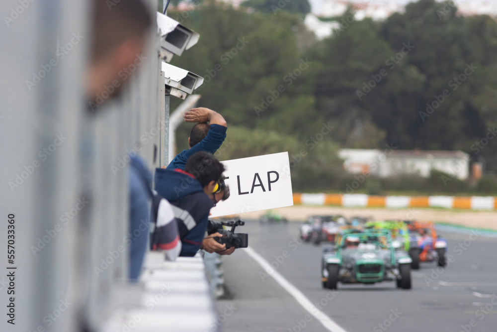 Kart racing - a man holding a placard with lap counting
