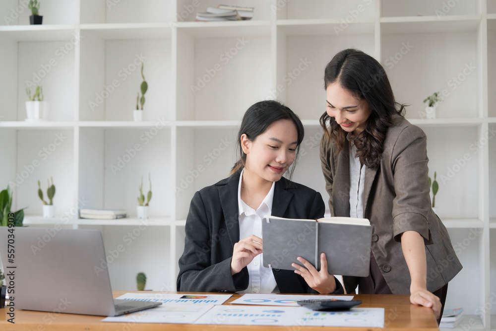 Two young Asian business woman talk, consult, discuss working with new startup project idea presentation analyze plan marketing and investment in the office. Two young Asian business woman talk, consult, discuss working with new startup project idea presentation analyze plan marketing and investment in the office.