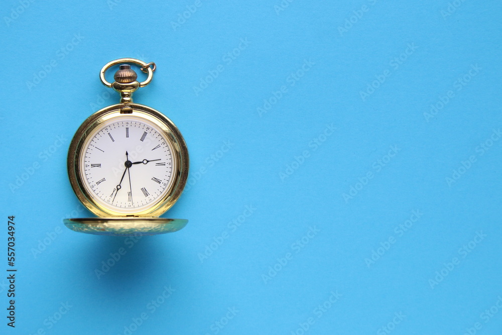 Blue background. Golden pocket watch on a blue background. Blue background. Golden pocket watch on a blue background.