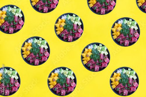 Poke salad in the bowl on the yellow background. Flat lay. Pattern.Top view.