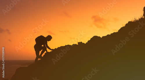 silhouette of a person climbing a mountain