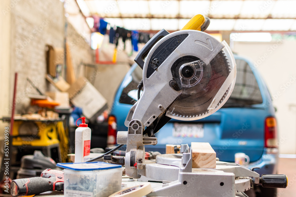yellow miter saw on workbench next to more woodworking tool yellow miter saw on workbench next to more woodworking tool