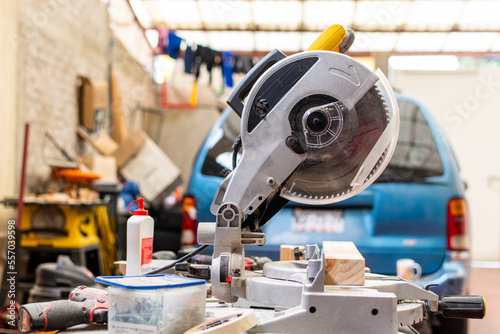 yellow miter saw on workbench next to more woodworking tool