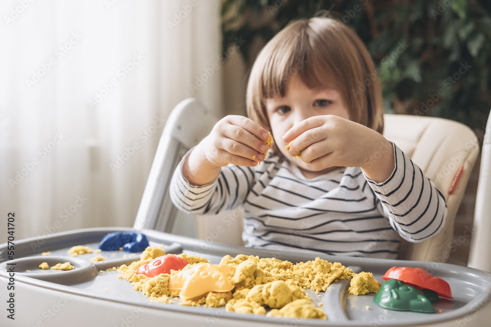 Cute little boy playing with kinetic sand. Development of fine motor skills. Early sensory education. Activities Montessori. Sensory plays at home. Cute little boy playing with kinetic sand. Development of fine motor skills. Early sensory education. Activities Montessori. Sensory plays at home.
